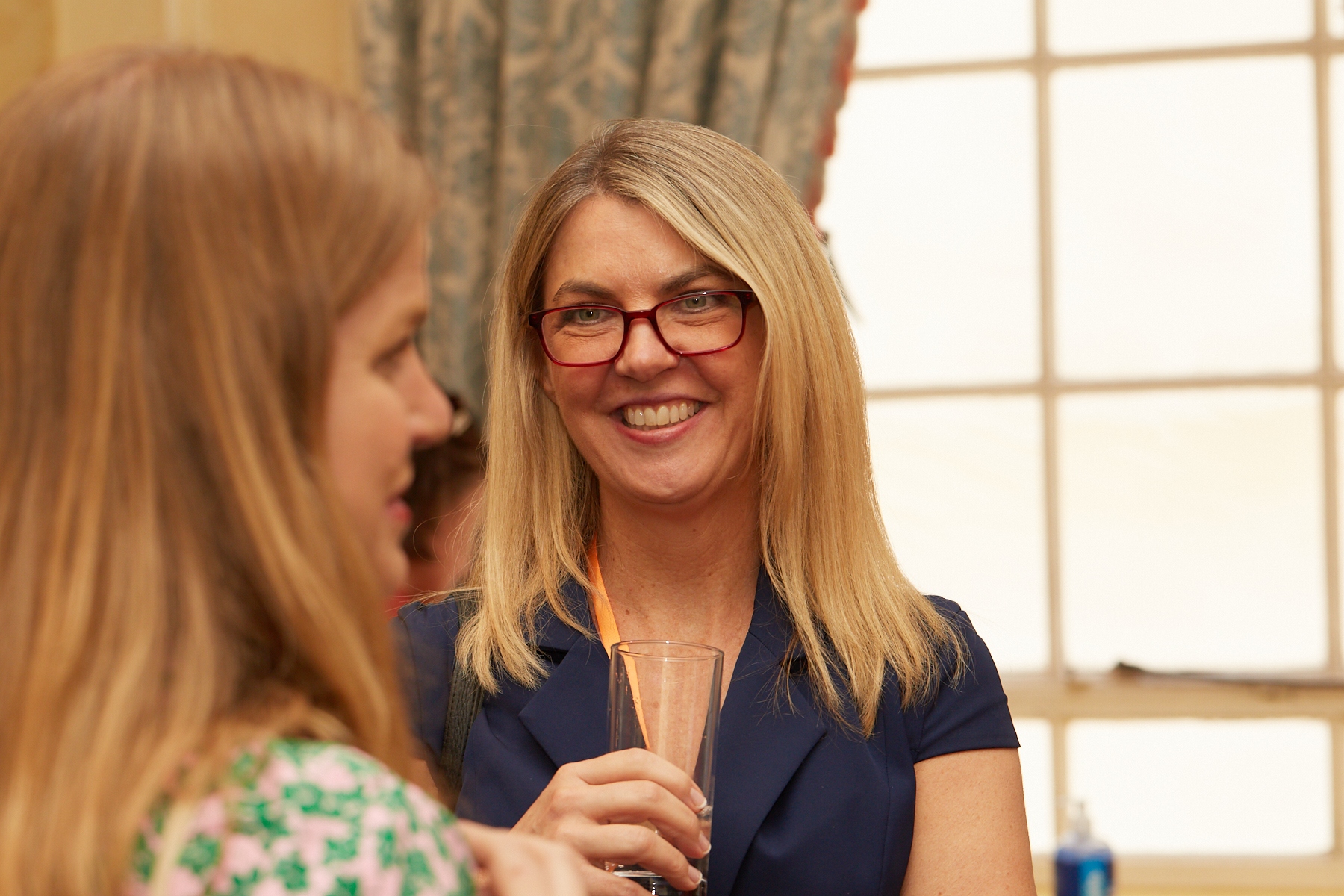 person with glasses on smiling having a conversation